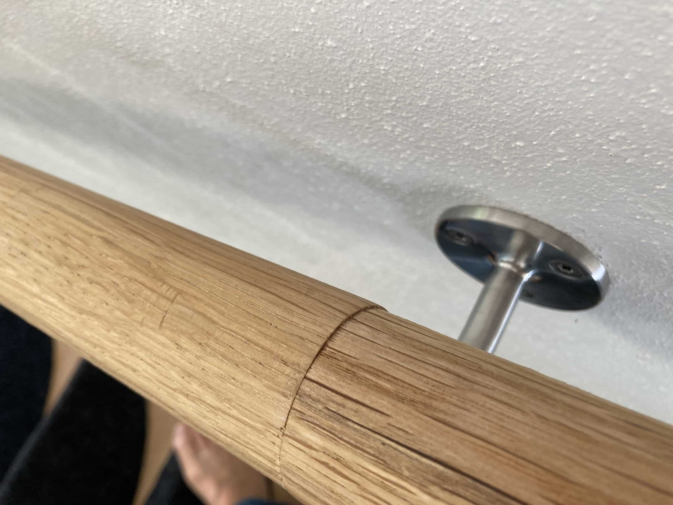 Väggmonterad ledstång längs en inomhustrappa.
