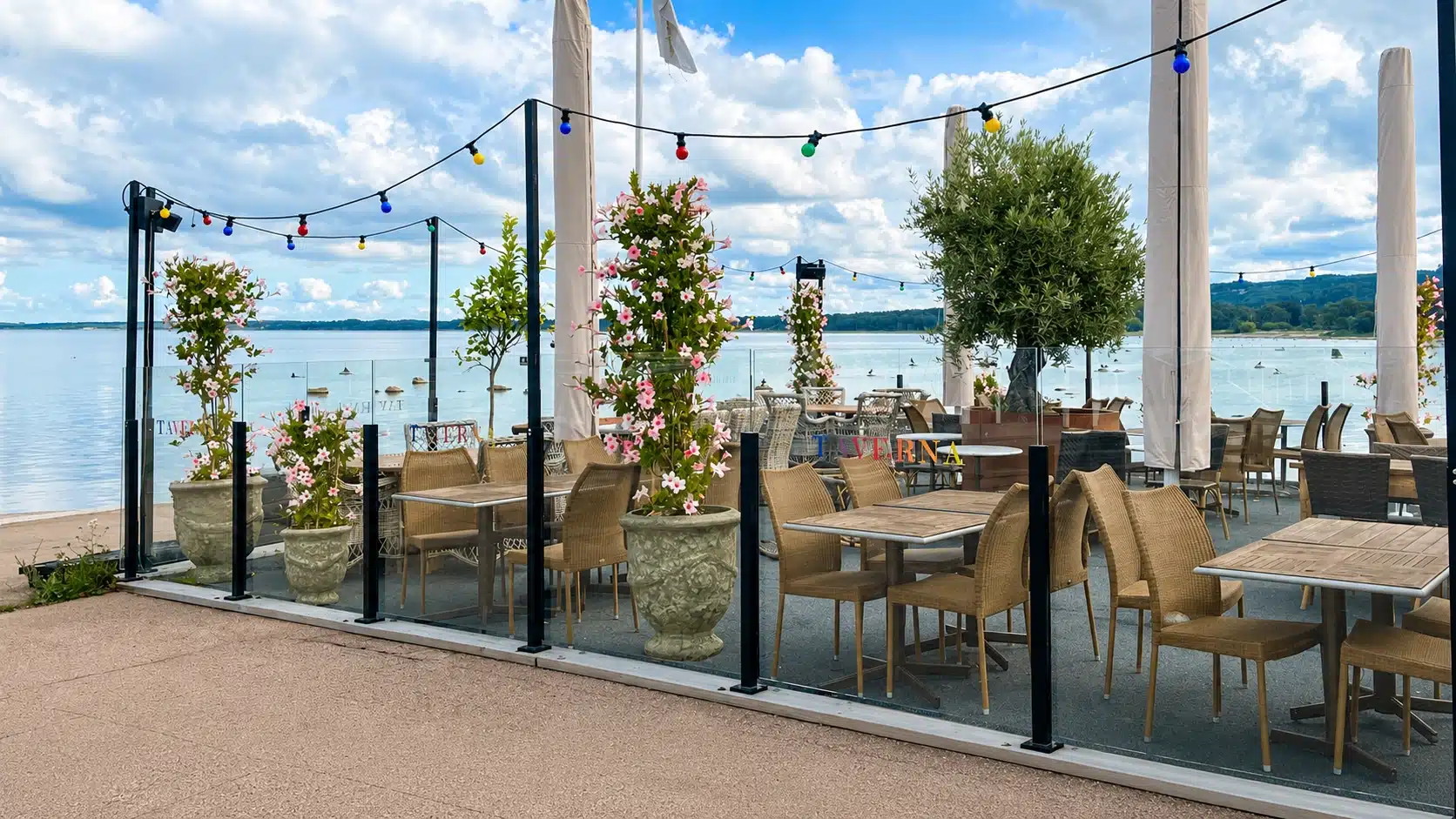 Glasvindskydd vid en uteplats med fri utsikt över havet.