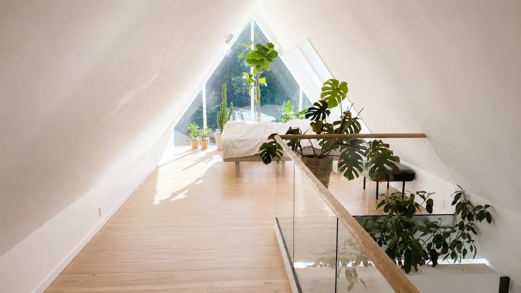 Inspiration för att bygga trappräcke inomhus med stolpfritt glasräcke, träöverliggare, trägolv och stort gavelfönster.